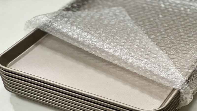 Protecting Baking Pan Shipments A protective layer of bubble wrap around a stack of new baking pans