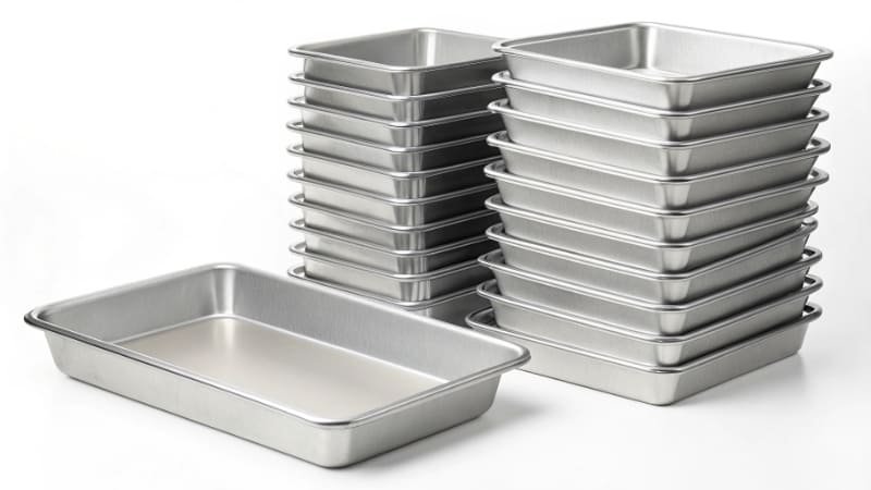 Sample Pan vs Bulk Order a single sample baking pan next to a large stack of pans
