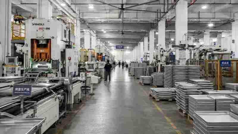 Reliable Commercial Bread Pan Manufacturer A large, modern factory floor with automated machinery for producing baking pans.