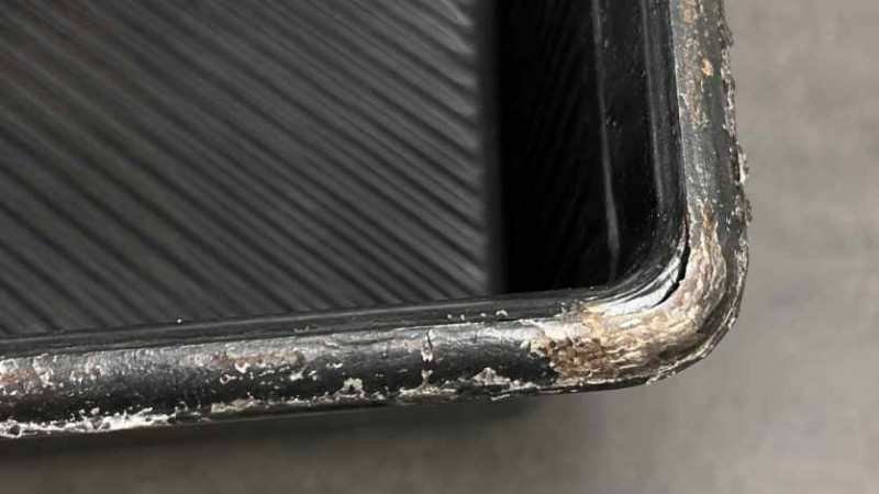 Close-up of a damaged non-stick coating on a baking tray